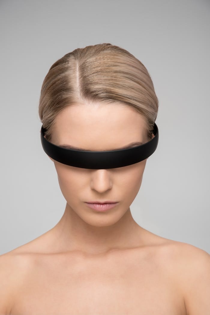 about-01 A captivating portrait of a woman with a sleek VR headset, depicting a futuristic theme.