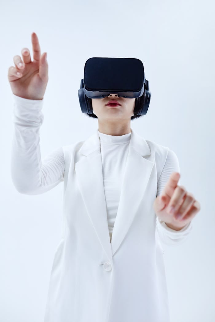 our-services-1 Woman using VR headset, exploring technology in a white setting.